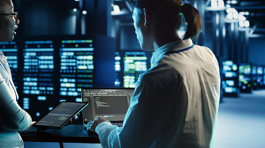 Consultants reviewing infrastructure data on a tablet inside a data hall